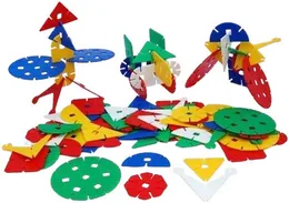 A scattered heap of interlocking plastic flower discs and petals in red, blue, green, yellow and white, with two assembled figures standing among them.