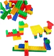 Large interlocking plastic bricks in red, blue, green and yellow, built into a train, a table and a low wall.