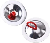 A pair of small polished metal finger cymbals with red elastic loops, one face up and one face down.