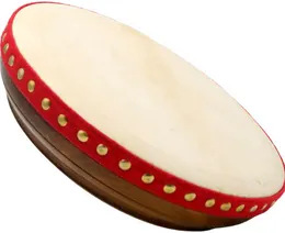 A shallow wooden frame drum with a pale hide head, a red rim and a ring of brass studs.