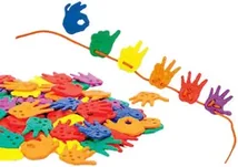A heap of small plastic hand shapes in many colours, with a line of them threaded onto an orange lace curving above.