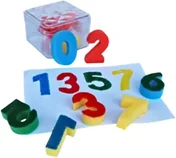 Sponge digits nought to nine in red, blue, green and yellow, some standing in a clear box, the rest scattered on a sheet of paper.