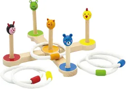 A wooden ring toss base with five pegs topped by painted animal heads, a ladybird, a frog, a cat, a bear and a chick, with white rings around them.