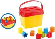 A yellow plastic basket with a red lid cut with shaped holes, a red handle, and coloured posting blocks in front of it.