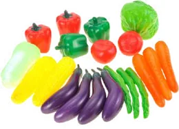 Plastic play vegetables laid out on white: red and green peppers, a cabbage, tomatoes, two ears of corn, four aubergines, green beans and carrots.