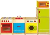 A group of natural wood play kitchen units with coloured doors in red, blue and yellow, a microwave on top and a green tall cupboard at the end.