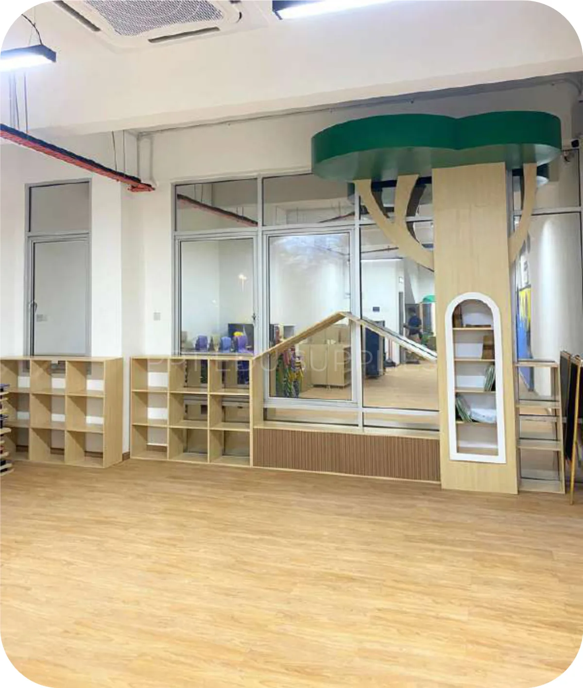 A playroom with pastel house frames, a white slide and artificial grass on the floor.