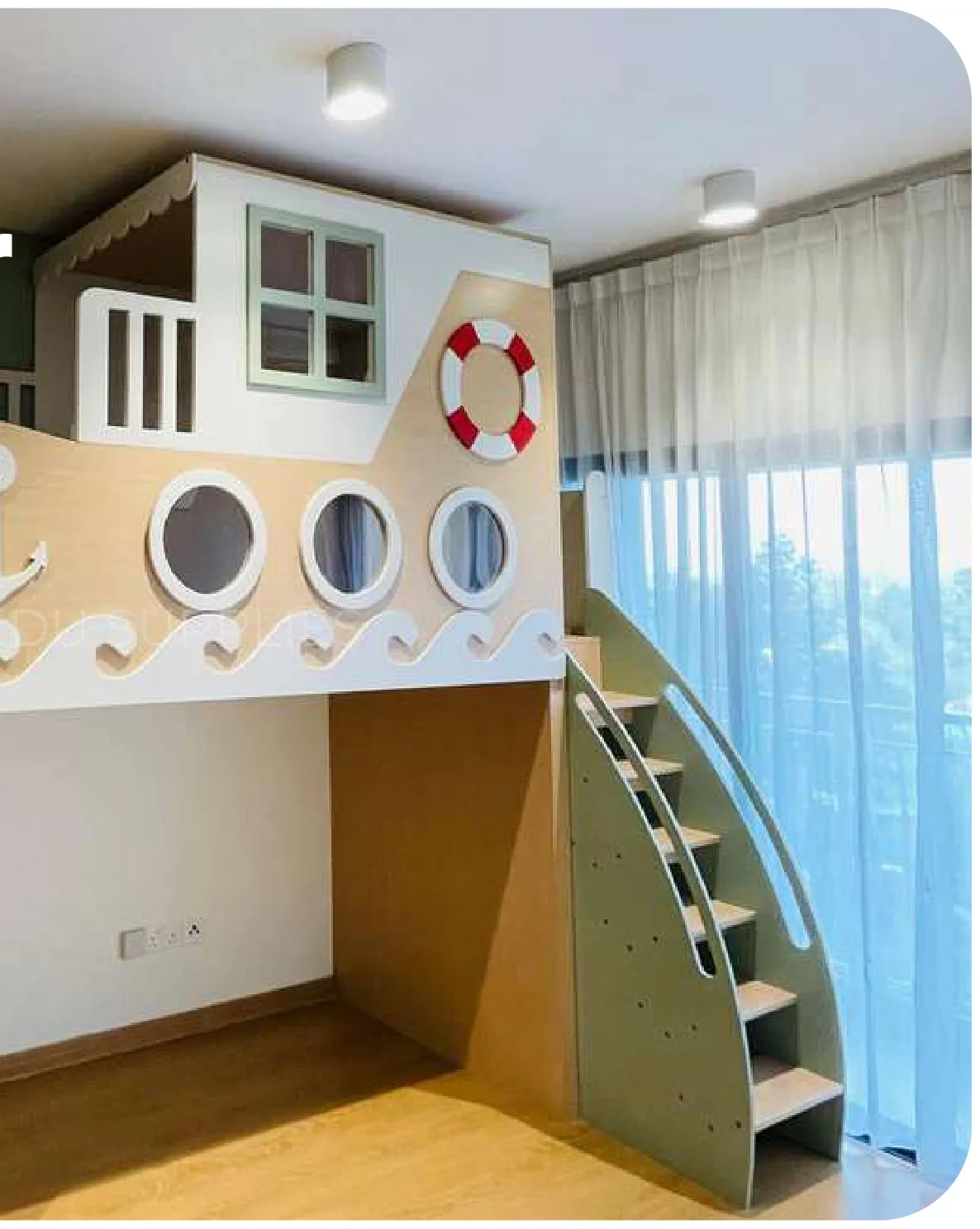 A nautical themed unit with a house shaped bunk above, a wall of portholes, a lifebuoy and an anchor, and a stair up the side.