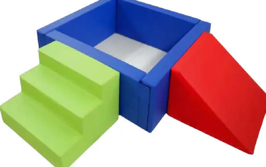 A blue walled ball pool with green steps up one side and a red wedge slide down the other.