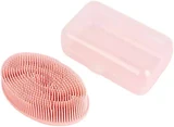 A pink silicone brush with dense soft bristles, beside the clear plastic case it comes in.