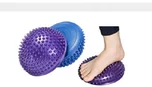 Purple spiked balance domes, one under a bare foot.